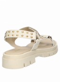 Elegante sandalia de mujer en cuero beige con tachas, diseño contemporáneo.