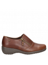 Zapato de cuero café para mujer, con cierre decorativo y banda elástica, versátil para ocasiones informales.