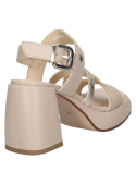 Sandalia de cuero beige con hebilla prominente en el tobillo, combinando confort y estilo para eventos al aire libre.