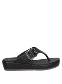 Calzado casual de cuero negro para mujer, destacando su tira gruesa en el empeine con hebilla decorativa y funcional.