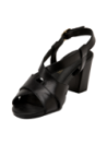 Sandalia minimalista de cuero negro con correa ajustable en el tobillo, combinable con vestidos veraniegos.