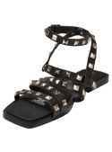 Sandalia de cuero negro, ideal para un look punk chic, combinable con jeans o faldas para un aire atrevido.