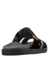 Calzado casual de cuero negro con diseño minimalista y detalles metálicos, ideal para ocasiones informales al aire libre.