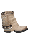 Botín de cuero taupe con detalles metálicos y tachas, perfecto para un look urbano y con personalidad femenina.