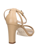 Sandalia de cuero beige con tiras cruzadas en el empeine, perfecta para combinar con falda o jeans ajustados.