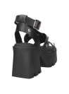 Sandalia de cuero negro con aplicaciones metálicas, perfecta para eventos informales y salidas nocturnas con un toque audaz.