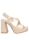 Sandalia femenina nude de charol con diseño moderno y sofisticado, ideal para un look urbano con pantalones pitillo.