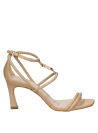 Calzado de cuero beige con sofisticado diseño de tiras y tacón fino, perfecto para combinar con vestidos de cóctel.