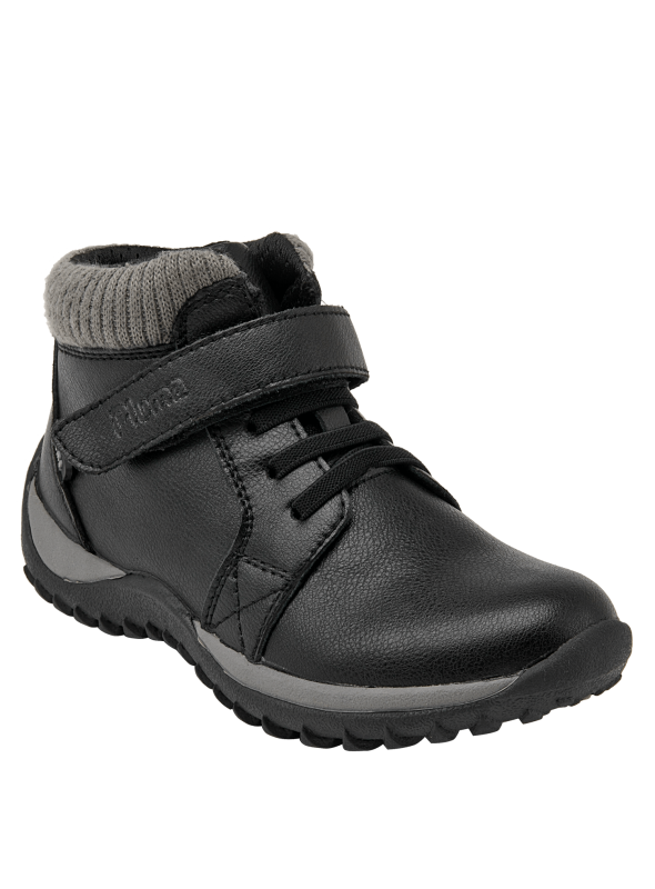 Moderno botín colegial negro para niño, diseñado para combinar con mezclilla o joggers en un entorno urbano.