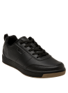 Zapatilla negra unisex de estilo colegial, corte bajo y aspecto elegante, ideal para combinar con jeans o ropa casual.