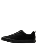 Zapatilla colegial negra unisex, versátil para combinar con jeans o pantalones cargo en un entorno casual.