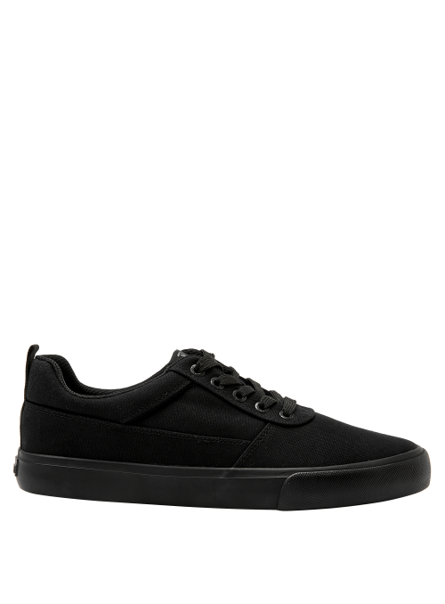 Zapatilla colegial unisex negra de diseño clásico con cordones y ojales metálicos, ideal para un look urbano y casual.