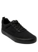Zapatilla colegial unisex negra de diseño clásico con cordones y ojales metálicos, ideal para un look urbano y casual.