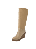 Bota casual beige de cuero con detalles de tachas, combinable con jeans ajustados o vestidos otoñales.