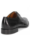 Elegante zapato de cuero negro para hombre con diseño brogue, adecuado para ocasiones formales como bodas y reuniones.