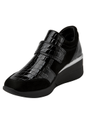 Zapatilla negra de charol de cuero para mujer, ideal para uso urbano con diseño moderno y juvenil.