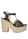Sandalia de cuero negro con diseño sofisticado, plataforma alta y tiras entrecruzadas, ideal para un look semiformal.