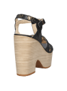 Sandalia negra de mujer en cuero, plataforma alta, tacón ancho y tiras cruzadas para un look moderno.