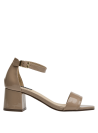 Sandalia taupe de charol minimalista con talón cuadrado y ajuste en el tobillo, ideal para bodas y encuentros al aire libre.