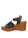 Sandalia femenina de cuero negro con acabado premium y taco cuña, ideal para un look veraniego.