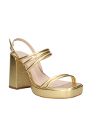Calzado femenino dorado de cuero, tiras cruzadas y taco grueso, versátil para looks casuales y elegantes.