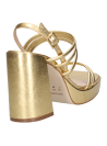 Elegante sandalia de cuero dorado con taco estable, adecuada para combinar con vestidos veraniegos o faldas largas.