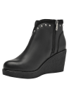 Botín negro de cuero para mujer, estilo casual, con tachas decorativas en la parte superior y costuras visibles.