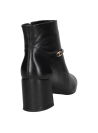 Botín casual de mujer en cuero negro, con adorno metálico en tira decorativa, combinando elegancia y practicidad.