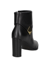 Botín elegante de cuero negro con hebilla moderna, solapa distintiva y taco alto, combinando estilo y confort.