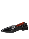 Calzado de cuero negro estilo mocasín femenino, con remaches decorativos y suela plana para comodidad diaria.