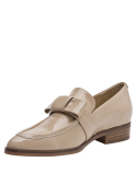 Mocasín de cuero beige para mujer con acabado brillante y detalle metálico, perfecto para uso diario con estilo.