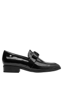 Zapato mocasín negro de cuero para mujer, adornado con lazo y detalle metálico, ideal para un estilo casual moderno.