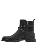 Botín negro de cuero con hebilla decorativa y suela gruesa tipo plataforma baja para comodidad y estabilidad.