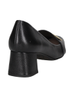 Mocasín de cuero negro para mujer con empeine cerrado y adorno metálico, ofreciendo comodidad y sofisticación.