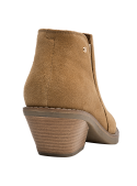 Botín camel de mujer en cuero gamuza, corte a media altura cubre tobillo, costuras visibles para durabilidad.