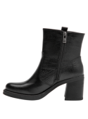 Elegante botín negro de cuero para mujer, con suela gruesa y tacón ancho, combina con jeans ajustados o faldas midi.