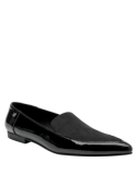 Zapato de cuero negro para mujer, estilo mocasín casual con costuras elegantes y detalle metálico moderno.