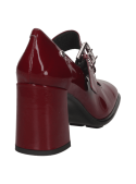 Calzado burdeos de charol con taco bloque que ofrece estabilidad, incorpora correa ajustable con hebilla en el empeine.