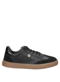 Zapatilla urbana de cuero negro para mujer, con suela gruesa y plana que ofrece estabilidad y comodidad al caminar.