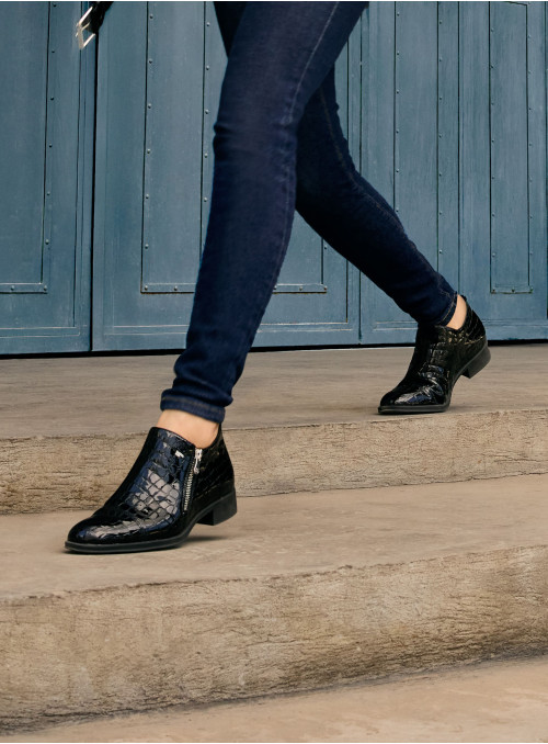 Calzado negro de cuero charol con cremallera lateral, combina estilo sofisticado y funcionalidad para el día a día.