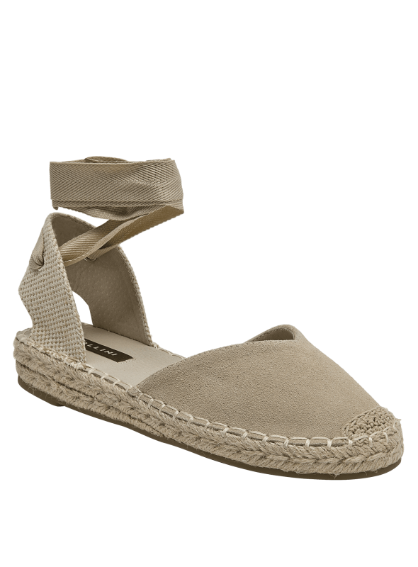 Alpargata boho-chic de cuero beige con cintas ajustables, combinable con pantalones de lino o jeans.