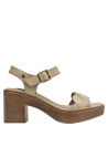 Elegante sandalia de cuero beige con textura suave y hebilla decorativa, adecuada para ambientes formales.