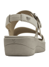 Sandalia de cuero blanco para mujer con hebilla metálica circular y diseño minimalista elegante.