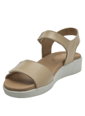 Sandalia beige de cuero para mujer con diseño minimalista y detalle metálico en cierre de velcro.