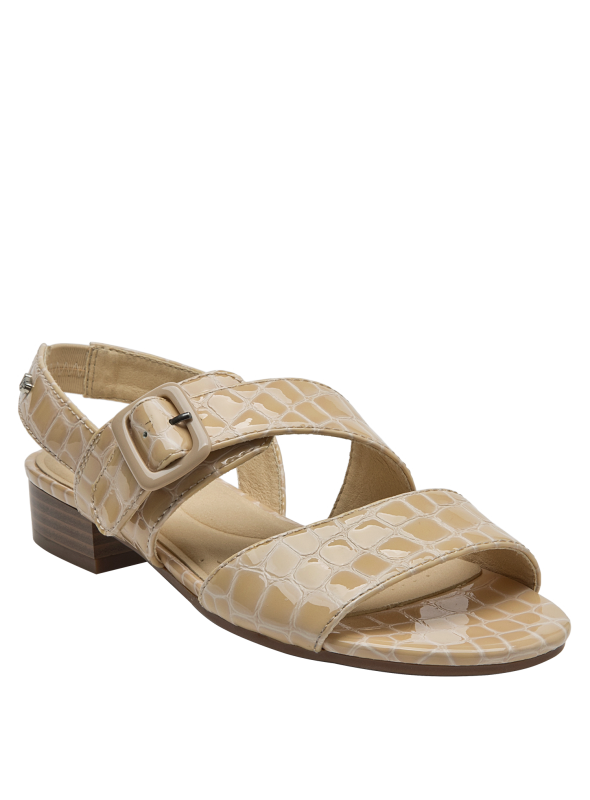Vista del lado de la sandalia de cuero beige con suela a juego y hebilla ajustable.