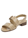 Detalle de hebilla grande a juego en sandalia formal beige de cuero con textura de cocodrilo.