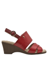 Sandalia de cuero rojo con hebilla ajustable en el talón, asegurando un ajuste perfecto y versatilidad.