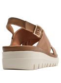 Sandalia de cuero camel para mujer con diseño cruzado y suela dentada blanca.
