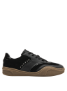 zapatilla deportiva negra de cuero con suela café y aplicaciones metálicas, ideal para estilo casual femenino
