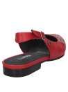 Detalle de ojales asimétricos en la parte delantera del zapato de cuero rojo.